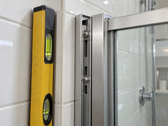 Adjustable aluminium shower screen wall profile with 15-25mm adjustment range fitted to an out-of-true UK bathroom wall